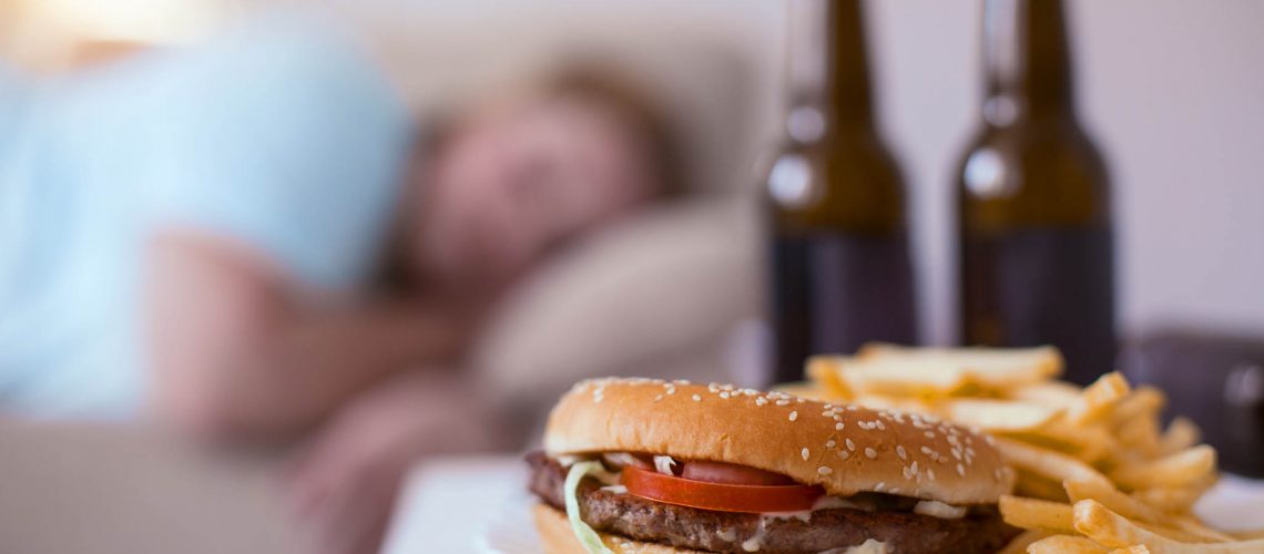 Junk food. Greasy nasty hamburger with fries lying on a plate